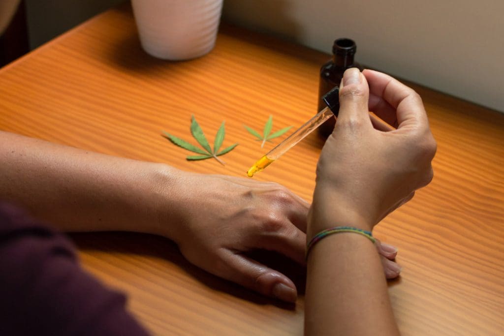 Woman applying CBD oil on her hand. 